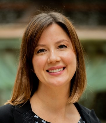 Smiling young white woman with brown hair in professional attire