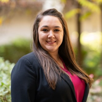 Young woman in business attire again soft-focus natural background